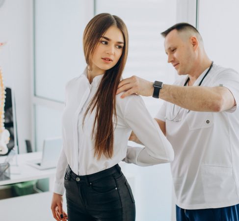 Female patient examining spine at physiotherapist at vertebrology center